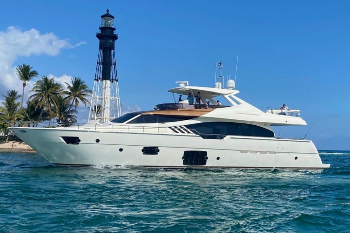 Yacht rental in Fort Lauderdale cruising past a lighthouse.