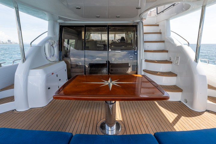 Aft deck seating and table aboard this yacht rental in Miami.