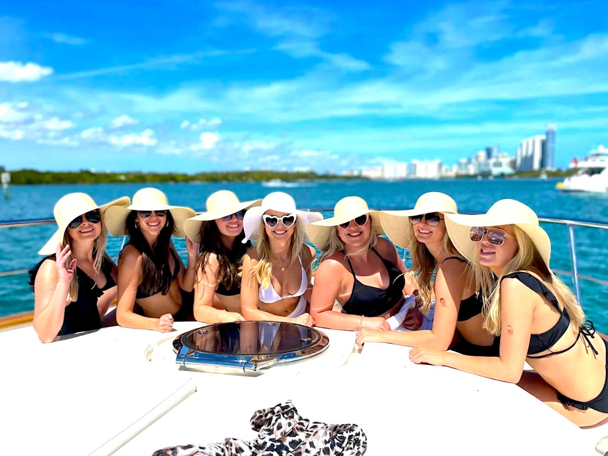 7 bachelorettes posing for pictures on the bow of this boat rental in Aventura.